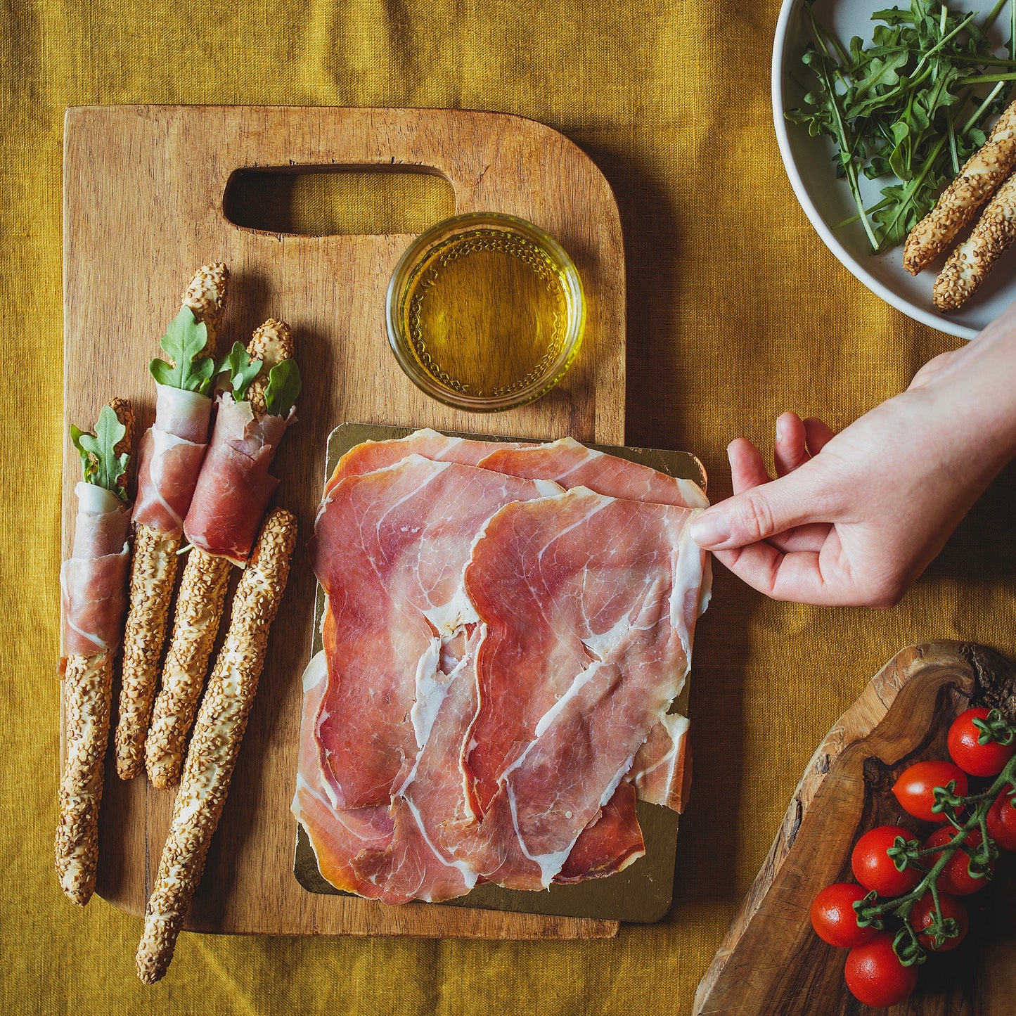 air-dried cured Welsh ham on a table and wrapped around breadsticks